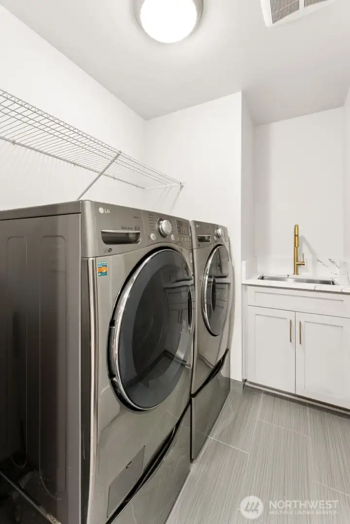 Spacious laundry room with a sink, washer and dryer included.