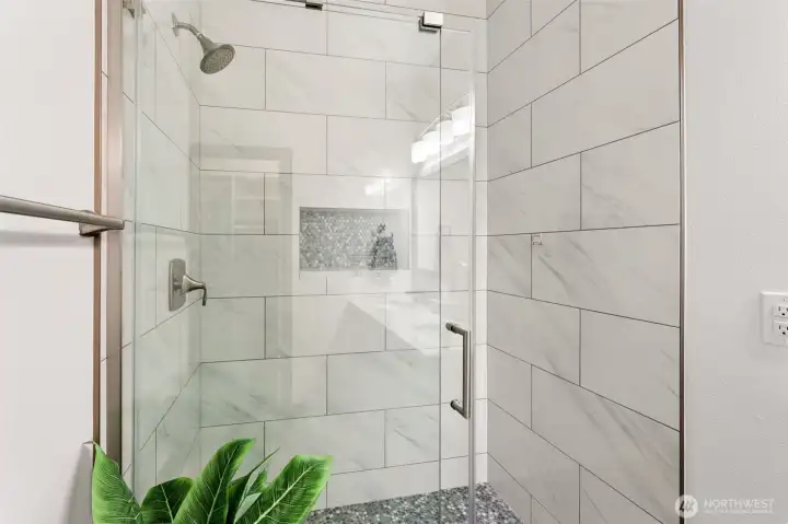 Tiled shower surround w/ glass enclosure, and new fixtures.