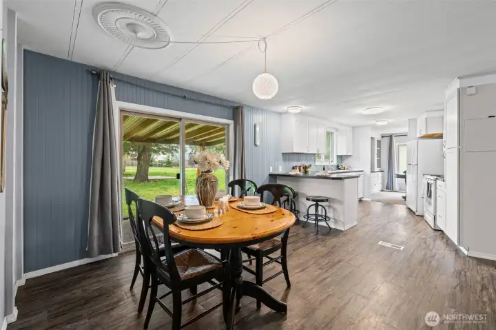 A wider view of the informal dining area, kitchen, and formal dining area.