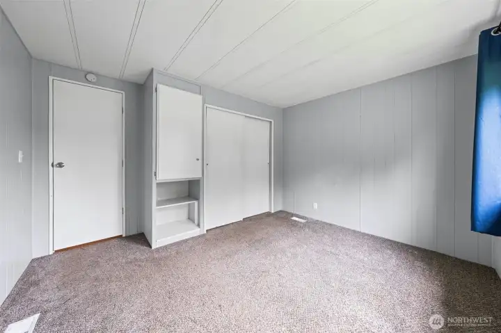 Guest bedroom 1 with wall-to-wall closet and built-in storage.