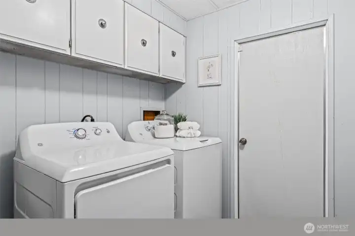 Laundry room with above cabinet storage.  The door leads out to the backyard.