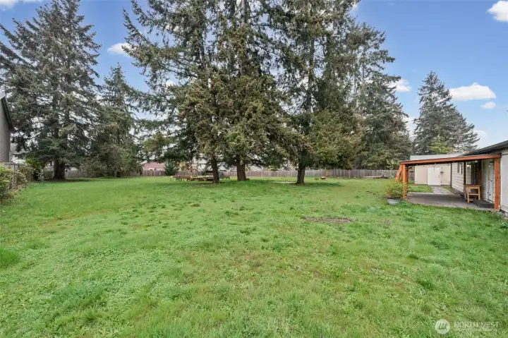 View of the backyard from the SW corner.  Ample space for gardening, recreation, animals, or future projects, this property offers endless potential to make it your own.