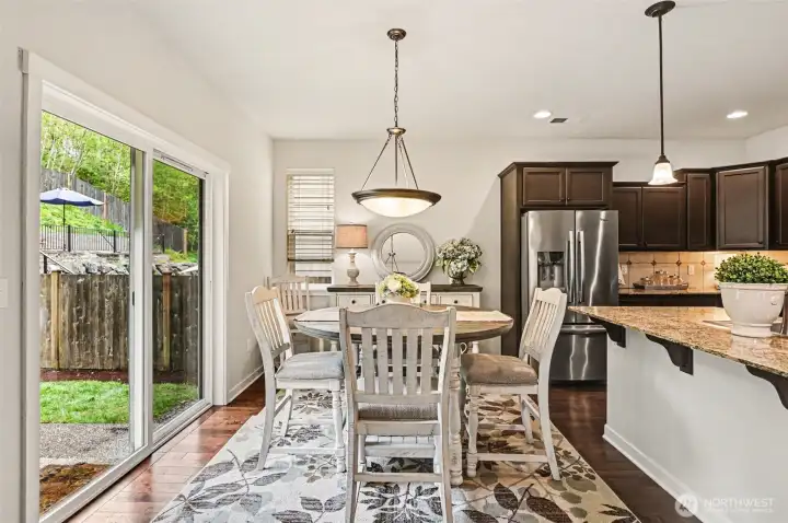 The chef's kitchen has bar seating and a dining area with access to the yard.