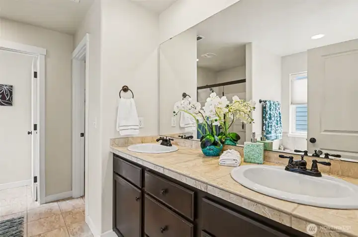 The primary suite bathroom includes a large soaking tub, walk-in closet and an adjacent laundry room.