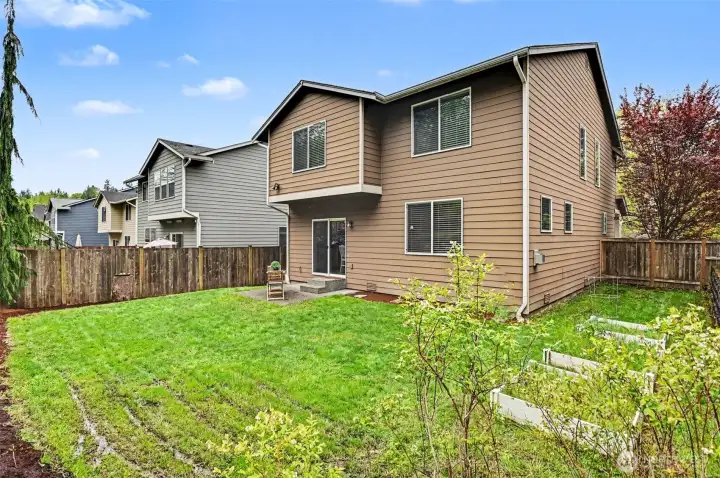 Fully-fenced yard with garden beds and a private greenbelt.