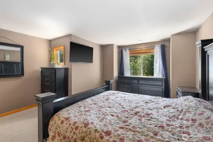 Expansive primary bedroom featuring generous natural light, recessed lighting, and plenty of room for a sitting area or additional furnishings.