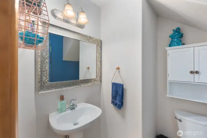 Convenient main floor powder room with pedestal sink and updated lighting.