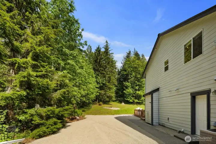 Expansive backyard with mature trees, open lawn space, and peaceful privacy surrounding the property.