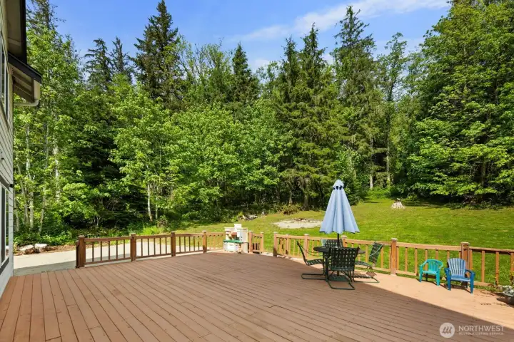 Spacious back deck with wooded views and seamless connection to the open outdoor living space.