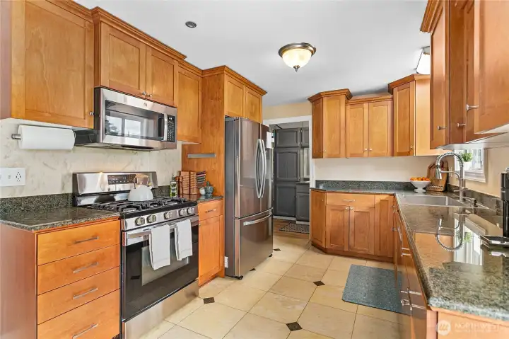 Kitchen features newer SS appliances and pantry/laundry/utility right off it