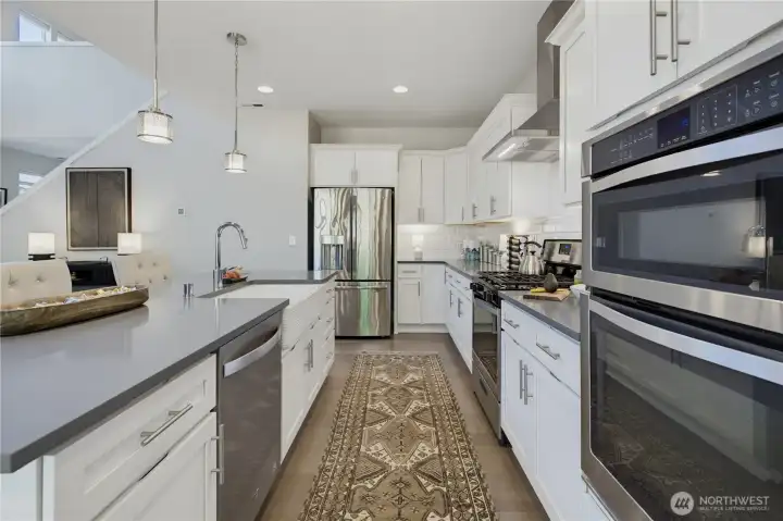 Clean, white subway tile backsplash, elegant quartz countertops and plenty of white cabinets. Clean, white subway tile backsplash, elegant quartz countertops and plenty of white cabinets.