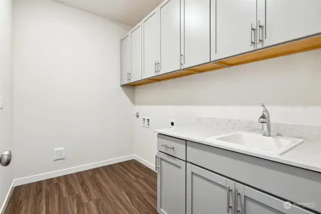 Laundry Room offers a Sink and Cabinets
