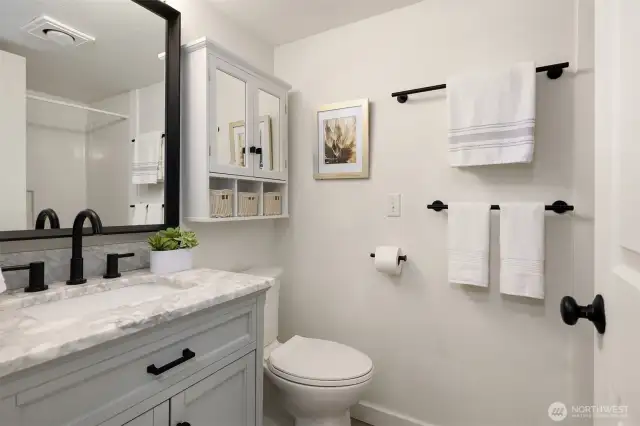 Updated bathroom with marble countertop and tile floors