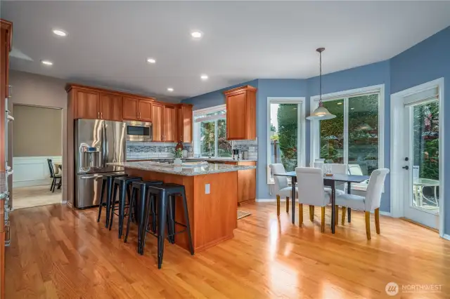 Nestled between the kitchen and family room is a cozy breakfast nook surrounded by windows framing lush backyard views.