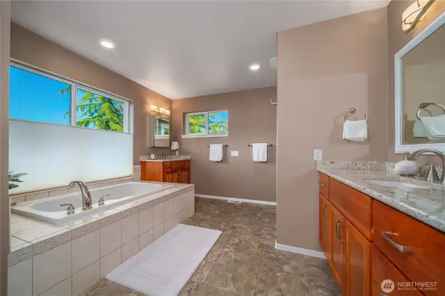 The refreshed ensuite bath features dual vanities, a soaking tub, and top-down bottom-up shades that let in light while maintaining privacy.