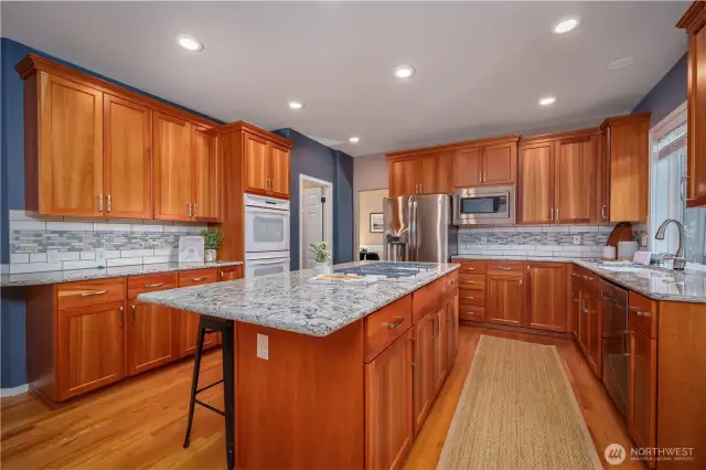 The updated kitchen features refaced cabinets, granite countertops, and a stylish tile backsplash.