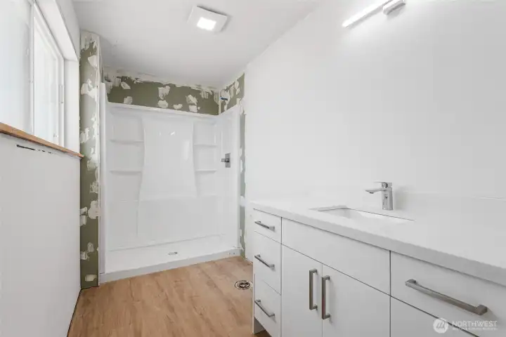 3/4 bath off of primary bedroom, new shower and cabinets, ready for your finishing touches.