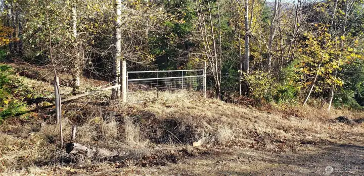 This gate in middle of the land on East side of road, leads to a building site.