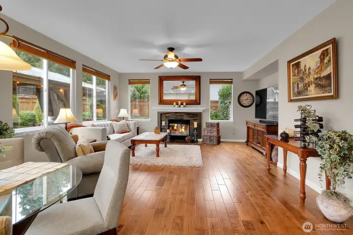 Open concept kitchen flows to family room with hardwood floors and gas fireplace
