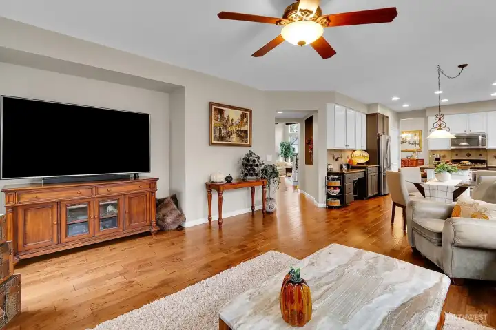 Open concept kitchen flows to family room with hardwood floors and gas fireplace