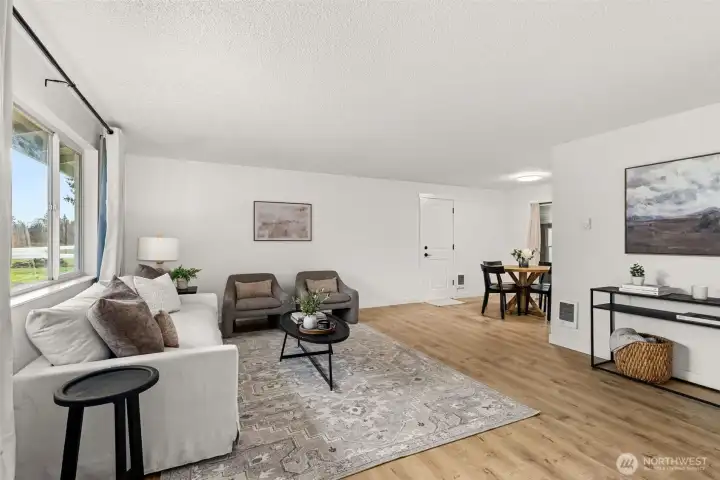 Great room with new flooring leading into dining area.