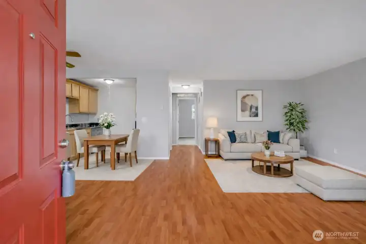 Step inside to a bright and open living space featuring warm flooring and a seamless flow into the kitchen.