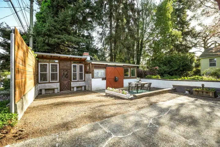 On the left is a work shop outbuilding and on the right a huge roofed fire pit!
