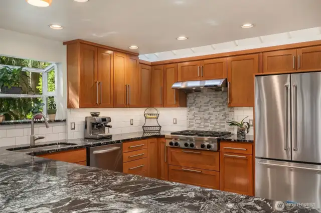 The garden window and skylights flood the kitchen with natural light. Notice the cherry cabinets.