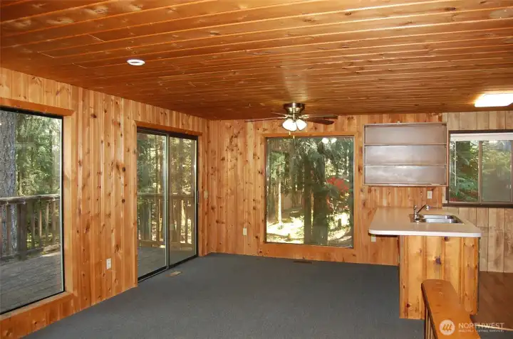 Dining room has large windows and slider to upper deck.
