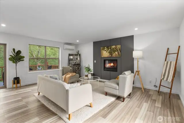 Windows flood the living area with light, showcasing the surrounding trees and forest.