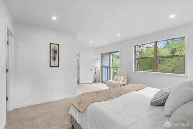 With its view of the trees, the primary bedroom is a tranquil, rejuvenating space.