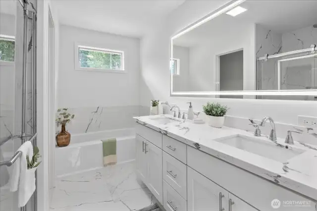 Spa like bathroom in the primary bedroom, with custom tile, quartz counters and LED mirror.