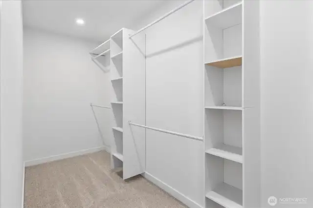 Huge walk in closet with built in cabinets.