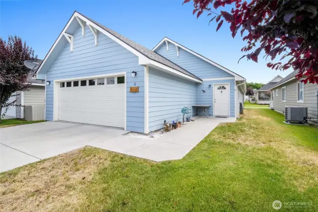 The front door is to the side of the garage.