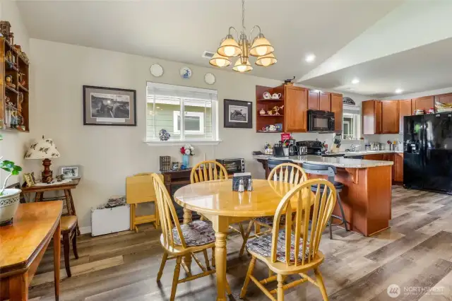 Here you have a large, brightly lit dining room and open kitchen area with Luxury Vinyl flooring and vaulted ceilings here as well.