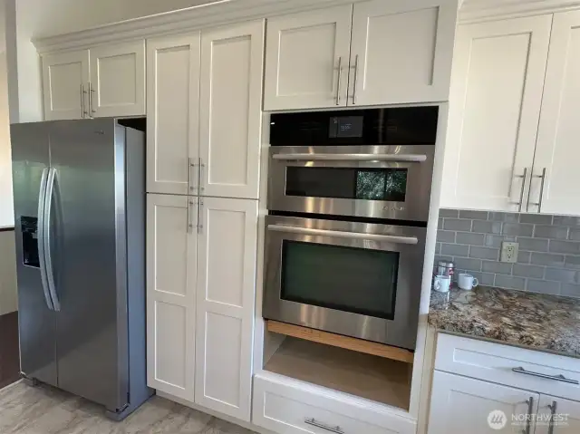 Soft close cabinets with pull out shelving and stainless steel appliances