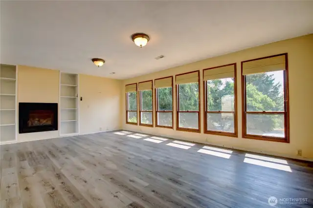 Large great room with wall of windows for great natural light. New gas fireplace with  built in shelves,
