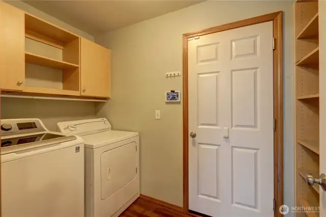 Spacious laundry room featuring cabinets for storage and a convenient door leading to the garage