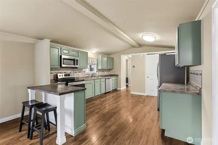 Chefs kitchen with SS appliances, large pantry cabinet and eating area.