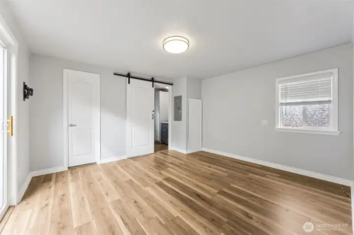 Master bedroom with walk-in closet and barn door leading to bathroom.