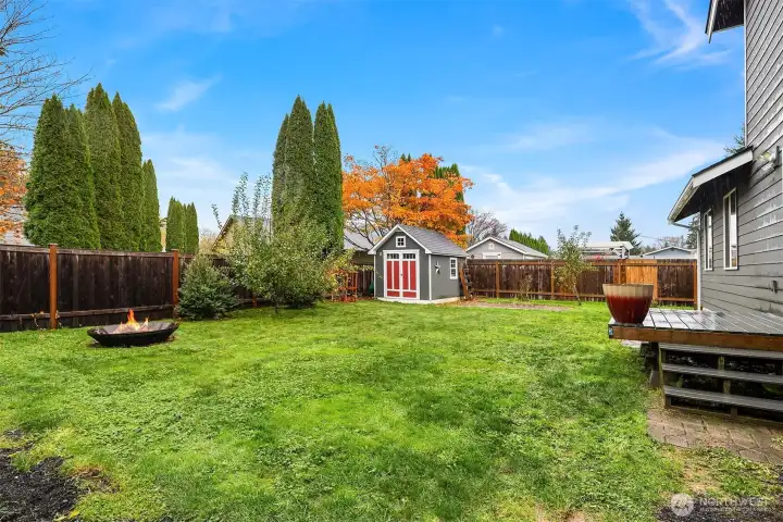 Nice fenced yard space with raised garden beds and storage shed