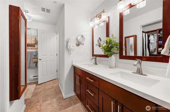 gorgeous primary bathroom sink area with quartz countertops and updated cabinets