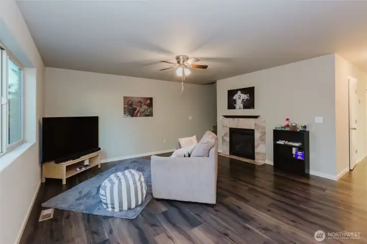 Living room with stairs leading to second floor and hallway to front entrance