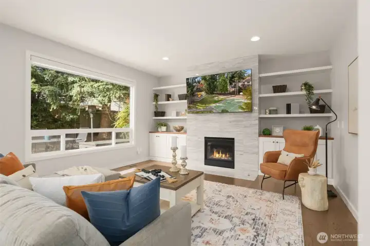 A warm gas fireplace framed by custom white built in bookcases anchor the family room.