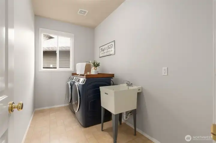 Main floor laundry room with a memorable washer and dryer set that stays with the home all contributing to a move-in ready environment!
