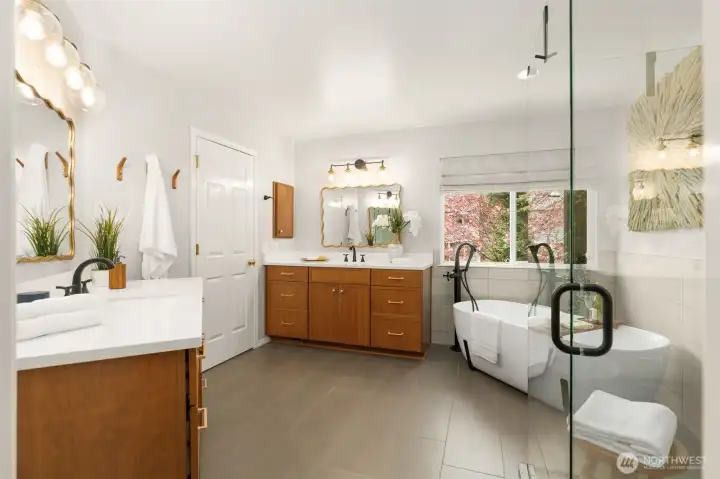 Freestanding tub with memorable faucet off the floor, dual split vanities, stylish mirrors and hardware.