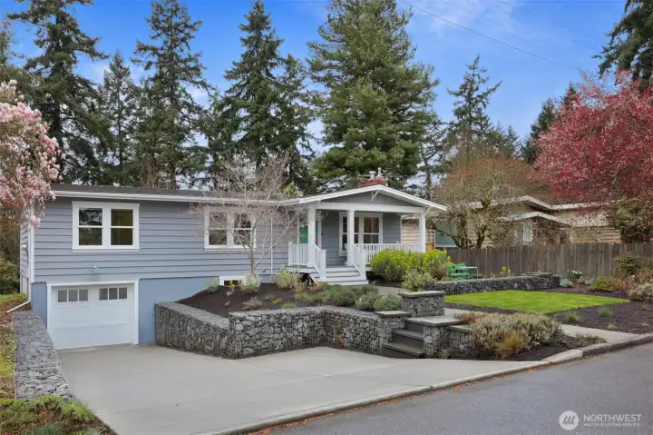 A widened and re-poured driveway with permitted drain, fresh paint on cedar siding, and thoughtful landscaping make for ideal curb appeal.
