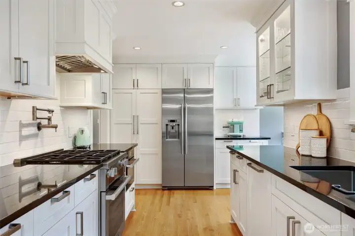 Barker cabinets (made in Portland), black slab granite counters, a Miele gas cooktop with handy pot filler, cabinet-paneled Bosch dishwasher, pull-out storage, cabinet lighting... Magazine-worthy!