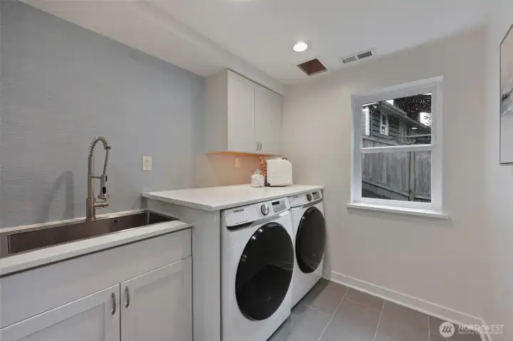 No creepy basement chores! Laundry day isn't so bad with a large utility sink, storage space, a folding shelf, and natural light.
