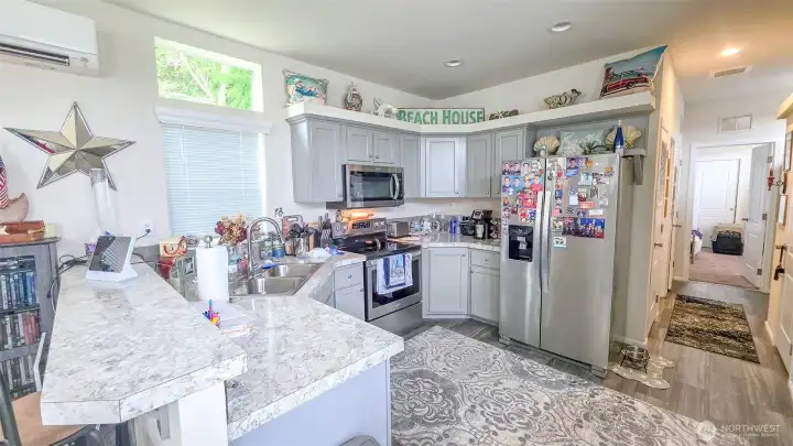 Open space to move around in the kitchen - all appliances included!  Hallway leads you down to bathroom and bedroom (and side door)